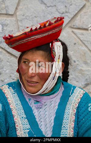 Peruanische Frau sitzt auf dem Platz von Ollantaytambo, Peru; Ollantaytambo, Peru Stockfoto