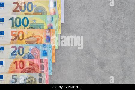 Die Euro-Banknoten sind auf grauem Hintergrund angeordnet, von oben sehen Euro-Banknoten unterschiedlicher Stückelungen in Bargeld, Zahlungssystem des EU-Countr Stockfoto
