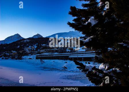 Herrlicher Sonnenuntergang in den verschneiten Schweizer Alpen mit Blick auf die Stadt St. Moritz, Schweiz Stockfoto