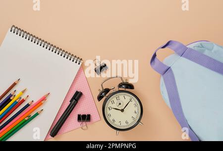 Zurück in die Schule, Schulfächer, Layout auf einem leichten fleischlichen Hintergrund. Notizblock, Rucksack, Stifte, Stifte, Wecker, Und anderen Werkzeugen. Banner mit Ort Stockfoto