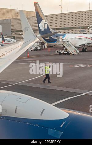 Mexiko-Stadt, Mexiko – Ein Bodenpersonal hilft einem abfliegenden AeroMexico Jet am Mexico City International Airport (Aeropuerto) Stockfoto