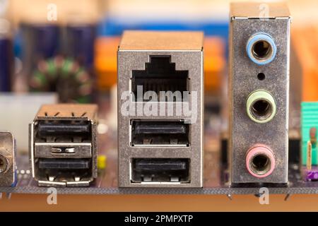 Elektrischer Stromkreis. Spitzentechnologie. Die Rückseite eines modernen Mainboards mit einem großen Satz an Anschlüssen zum Anschluss von Peripheriegeräten für einen Desktop-Computer Stockfoto