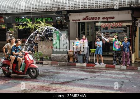 Pak Kret, Thailand. 14. April 2023. Eine thailändische Familie vor ihrem Laden gießt Motorradfahrer während des traditionellen Festivals in der Stadt Pak Kret in der Provinz Nonthaburi mit Wasser ein. Das Songkran Festival ist ein traditionelles buddhistisches Festival, das den Beginn des thailändischen Neujahrs markiert. Zusätzlich zu traditionellen Wasserritualen und Straßenpartys gibt es weitere wichtige Aktivitäten, an denen die Thailänder in dieser Woche teilnehmen, um an traditionellen buddhistischen Ritualen teilzunehmen. Kredit: SOPA Images Limited/Alamy Live News Stockfoto