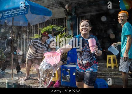 Pak Kret, Thailand. 14. April 2023. Thailändische Bewohner feiern das thailändische Neujahr, während sie während des traditionellen Festivals in der Stadt Pak Kret in der Provinz Nonthaburi Wasser in Fahrzeuge gießen. Das Songkran Festival ist ein traditionelles buddhistisches Festival, das den Beginn des thailändischen Neujahrs markiert. Zusätzlich zu traditionellen Wasserritualen und Straßenpartys gibt es weitere wichtige Aktivitäten, an denen die Thailänder in dieser Woche teilnehmen, um an traditionellen buddhistischen Ritualen teilzunehmen. Kredit: SOPA Images Limited/Alamy Live News Stockfoto