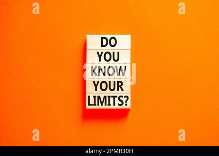 Kennen Sie das Limitsymbol? Konzeptbegriffe kennst du deine Grenzen bei Holzblöcken? Schöner orangefarbener Tischhintergrund. Das Geschäft kennen Sie doch Stockfoto