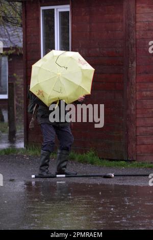 KIEW, UKRAINE - 14. APRIL 2023 - Ein Fischer besitzt einen Schirm im Muromets Park, Kiew, Hauptstadt der Ukraine. Stockfoto