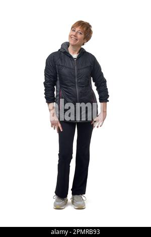 Eine Frau in Sportkleidung, die auf weißem Hintergrund lächelt Stockfoto