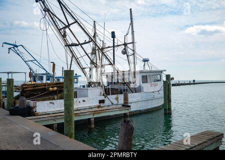 ROCKPORT, TX - 14. FEBRUAR 2023: Mehrere kommerzielle Fischerboote, die an einem überwiegend bewölkten Tag an einem Dock im Yachthafen in Rockport, Texas, festgemacht wurden. Stockfoto