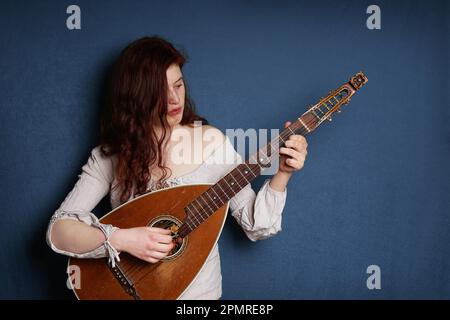 Junge Frau spielen alte Vintage laute String Instrument Stockfoto