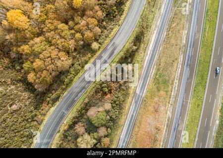 Ein Luftblick auf einen langen, geraden und leeren mehrspurigen Highway, umgeben von ländlichen Landschaften Stockfoto