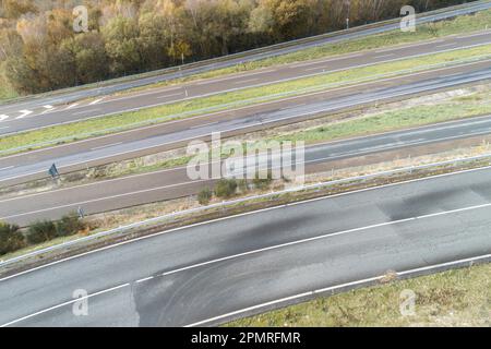 Ein Luftblick auf einen langen, geraden und leeren mehrspurigen Highway, umgeben von ländlichen Landschaften Stockfoto