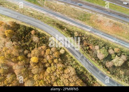 Ein Luftblick auf einen langen, geraden und leeren mehrspurigen Highway, umgeben von ländlichen Landschaften Stockfoto