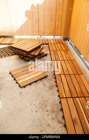 Verlegung von Holzfliesen auf dem Balkon, Deutschland Stockfoto