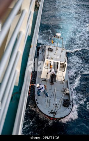 Cartagena, Kolumbien - 31. März 2023: Pilotboot neben einem Kreuzfahrtschiff, das sich darauf vorbereitet, den Piloten zurück an Land zu bringen. Stockfoto