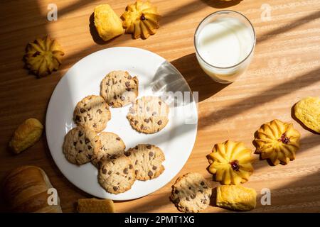 Glasbecher mit frischer Milch, Schokoladenkekse, köstliches Getränk und hausgemachte Speisen, süßer Snack Stockfoto
