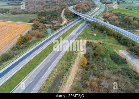 Luftaufnahme einer Landstraße ohne Verkehr, umgeben von üppiger grüner Vegetation Stockfoto