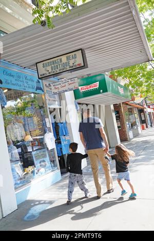 Shrunken Head Boutique mit UNC-Mechaniker. Ein Mann mit Kindern, der auf der Franklin Street in Chapel Hill, North Carolina, einkaufen geht Stockfoto