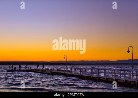 Farbenfroher Himmel in den Farben des Sonnenuntergangs über dem Lake Macquarie vom Murrays Beach Pier in Australien. Stockfoto