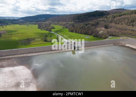 PRODUKTION - 13. April 2023, Hessen, Bad Soden-Salmünster: Kleine Wasserstände im Reservoir der Kinzigtalsperre (Foto mit Drohne). Seit Mitte 2022 wurde der Behälter aufgrund einer alle 20 Jahre stattfindenden Sicherheitsinspektion zu einem gewissen Grad entleert. Nach der erzwungenen Winterpause sollen die umfassende Sicherheitsüberprüfung der Kinzigtalsperre und die damit verbundene Rehabilitation fortgesetzt werden. (Zu dpa 'die Arbeit an der Kinzigtalsperre geht nach den Winterferien weiter') Foto: Sebastian Gollnow/dpa Stockfoto