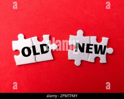 Weißes Puzzle mit dem Wort "ALT NEU" auf rotem Hintergrund. Geschäftskonzept. Stockfoto