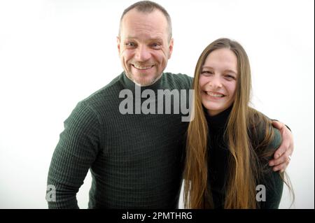 Schönes Glück Modepaar hübsche, lächelnde rothaarige Frau und stilvoller Hipster attraktiver Mann sitzt und umarmt sich auf weißem Hintergrund. Hochwertiges Foto Stockfoto