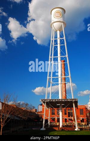 Ein großer Wasserturm, der die Marke eines Zigarettenunternehmens trägt, erinnert an die Tabakverarbeitungsanlage, die einst in Durham, NC, vorherrschte Stockfoto