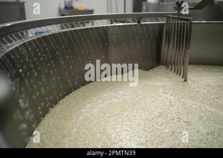 Quark und Molke mit heißem Wasser in der Käsefabrik. Speicherplatz kopieren. Stockfoto