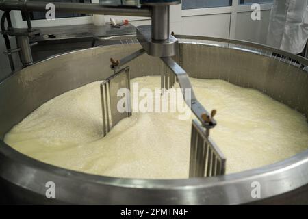 Mischen der Milch in großen Edelstahltanks bei der Käseherstellung Stockfoto