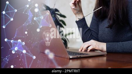 Ein Mädchen, das mit einer Brille in der Hand hinter einem Notebook denkt Trendanalyse Stockfoto