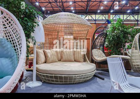 Rundes Bett aus weißem Rattan mit Baldachin und Kissen. Stockfoto