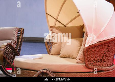 Runder Rattan-Bett mit Bezug Stockfoto