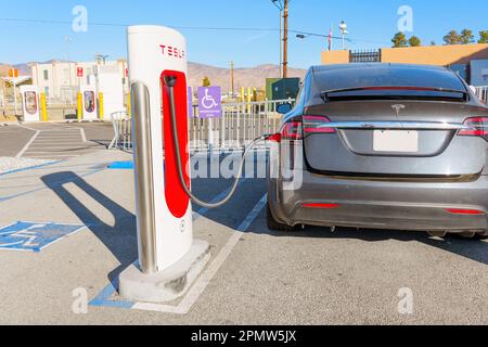 Kalifornien, USA - 23. Dezember 2022: Rückansicht eines Tesla-Fahrzeugs, das an einer Supercharger-Station aufgeladen wird Stockfoto