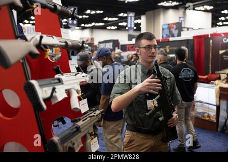 Indianapolis, Usa. 15. April 2023. Ein Arbeiter zeigt ein Gewehr am Stand von Tokarev während der jährlichen Tagungen und Ausstellungen der National Rifle Association im Indiana Convention Center in Indianapolis. Das Forum ist Teil der jährlichen Tagungen und Ausstellungen der National Rifle Association, die voraussichtlich rund 70.000 Gäste anziehen werden. Heute geöffnet und bis Sonntag geöffnet. Kredit: SOPA Images Limited/Alamy Live News Stockfoto