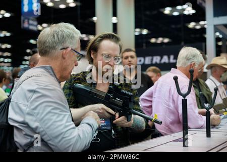 Indianapolis, Usa. 15. April 2023. Gäste können ein Gewehr bei den jährlichen Tagungen und Ausstellungen der National Rifle Association im Indiana Convention Center in Indianapolis ausstellen. Das Forum ist Teil der jährlichen Tagungen und Ausstellungen der National Rifle Association, die voraussichtlich rund 70.000 Gäste anziehen werden. Heute geöffnet und bis Sonntag geöffnet. Kredit: SOPA Images Limited/Alamy Live News Stockfoto