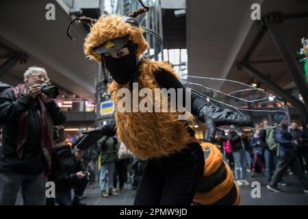 Am 15. April 2023 hielt die Umweltbewegung Extinction Rebellion heute am Hauptbahnhof eine kreative Blitzmeute ab, um die Aufmerksamkeit auf das fortschreitende weltweite Aussterben von Arten zu lenken. Etwa 20 Amateurschauspieler in fantasievollen Tierkostümen und Geschäftskleidung führten eine Pantomime-Szene auf, die veranschaulichte, wie die Zerstörung des Ökosystems unsere Existenzgrundlage gefährdet. Passanten am Bahnhof wurden ermutigt, eine Pause einzulegen und sich „der Bedrohung durch die ökologische Krise zu stellen“, so ein Sprecher. Die Gruppe verlangt von der Regierung einen wirksamen Artenschutz Stockfoto