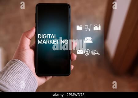 Frau Usign Smartphone mit „Digital Marketing“ auf dem Bildschirm und VR-Schnittstelle. Technologiekonzept für digitales Marketing. Internet. Online. Stockfoto