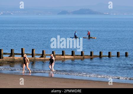 Edinburgh, Schottland, Großbritannien. 15. April 2023 Einige Aktivitäten am frühen Morgen am Strand von Portobello mit Menschen, die den milden Start in den Tag mit blauem Himmel und Sonnenschein genießen. Wildes Schwimmen und Paddeln. Blick in Richtung Inchkeith. Kredit: Craig Brown/Alamy Live News Stockfoto