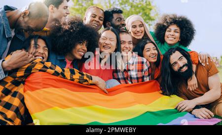 Fröhliche Menschen mit lgbt-Regenbogenflagge im Freien - Diversity Concept - Weiche Fokussierung auf das Gesicht junger asiatischer Frauen Stockfoto