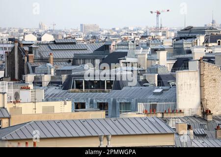 Ein faszinierendes Luftfoto der einzigartigen Verschlingung metallischer Dächer, das den unverwechselbaren architektonischen Charme von Paris, Frankreich, zeigt Stockfoto