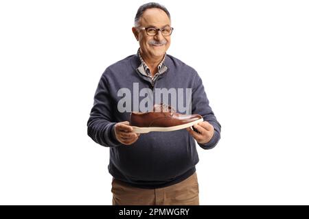 Glücklicher reifer Mann mit einem braunen Lederschuh isoliert auf weißem Hintergrund Stockfoto