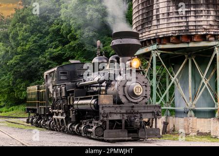 Cass, West Virginia, 18. Juni 2022 - an Antique Shay Steam Locomotive, Steamed Up, Blowing Smoke, Sitting by a Water Tower, Getting Ready for Work Stockfoto