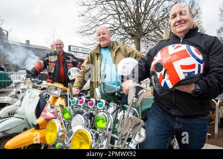 London, Großbritannien. 15. April 2023 Mitglieder des F.A.B. -Motorroller-Clubs von Hornchurch posieren mit ihren alten Rollern beim Classic Car Boot Sale in Granary Square, King’s Cross. Die Veranstaltung feiert alles, was Vintage ist, von Mode und Schmuck bis hin zu Haushaltswaren und Schallplatten, vor dem Hintergrund von Oldtimer-Fahrzeugen. Kredit: Stephen Chung / Alamy Live News Stockfoto