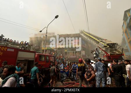 Dhaka. 15. April 2023. Menschen versammeln sich in der Nähe des Ortes, an dem ein massiver Brand ausbrach, auf einem beliebten Bekleidungsmarkt in Dhaka, Bangladesch, am 15. April 2023. Am Samstagmorgen brach hier das Feuer aus. Ershad Hossain, leitender Offizier der Feuerwehr und des Zivilverteidigungsamtes, sagte Xinhua, dass 30 Feuerwehrfahrzeuge das Feuer im großen „Neuen Supermarkt“ der Stadt bekämpften. Kredit: Xinhua/Alamy Live News Stockfoto