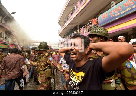 Dhaka. 15. April 2023. Ein Mann weint in der Nähe der Stelle, wo ein massiver Brand ausbrach, auf einem beliebten Bekleidungsmarkt in Dhaka, Bangladesch, am 15. April 2023. Am Samstagmorgen brach hier das Feuer aus. Ershad Hossain, leitender Offizier der Feuerwehr und des Zivilverteidigungsamtes, sagte Xinhua, dass 30 Feuerwehrfahrzeuge das Feuer im großen „Neuen Supermarkt“ der Stadt bekämpften. Kredit: Xinhua/Alamy Live News Stockfoto