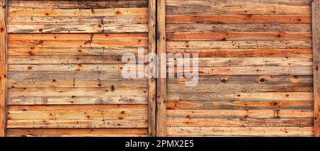 Abgenutzte und rustikale Holzplanken dieser Wand haben im Laufe der Zeit einen wunderschönen, natürlichen Orange-Farbton angenommen. Die Kombination aus Textur und Farbe sorgt für ein warmes A Stockfoto
