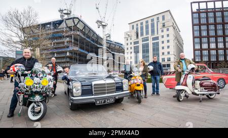 London, Großbritannien. 15. April 2023 Mitglieder des F.A.B. -Motorroller-Clubs von Hornchurch posieren mit ihren alten Rollern neben dem 1972 Mercedes W114, der zuvor Paul Weller aus dem Jam gehörte, auf dem Classic Car Boot Sale in Granary Square, King’s Cross. Die Veranstaltung feiert alles, was Vintage ist, von Mode und Schmuck bis hin zu Haushaltswaren und Schallplatten, vor dem Hintergrund von Oldtimer-Fahrzeugen. Kredit: Stephen Chung / Alamy Live News Stockfoto