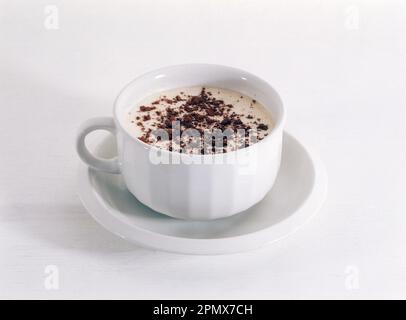 Cappuccino-Kaffee mit Schokoladenstreuseln in Weißbecher und Untertasse Stockfoto