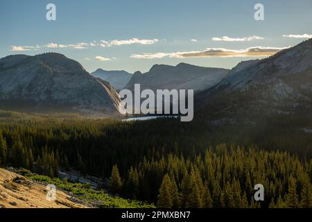 Das Sonnenlicht durchbricht die Berge und trifft auf den Tenaya Lake in Yosemite Stockfoto