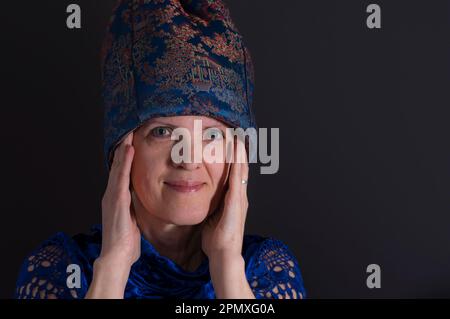 Nettes unauffälliges Porträt einer reifen Ukrainerin in blauer orientalischer Kleidung Stockfoto