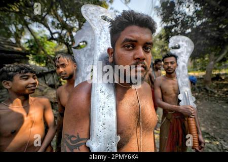 Kalyani, Indien. 14. April 2023. Hindu-Anhänger posieren mit Schwertern während des Charak Puja Festivals in einem Dorf in der Nähe von Kalyani. Das Charak Festival ist eines der ältesten Volksfestivals, bei dem Anhänger ihren Glauben zeigen, indem sie sich selbst Schmerz zufügen, in dem Glauben, dass Lord Shiva ihnen helfen wird, Probleme in ihrem täglichen Leben zu überwinden. Kredit: SOPA Images Limited/Alamy Live News Stockfoto